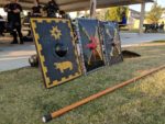 Three shields stand propped up behind a rattan polearm near the pavilion where we hold fighter practice